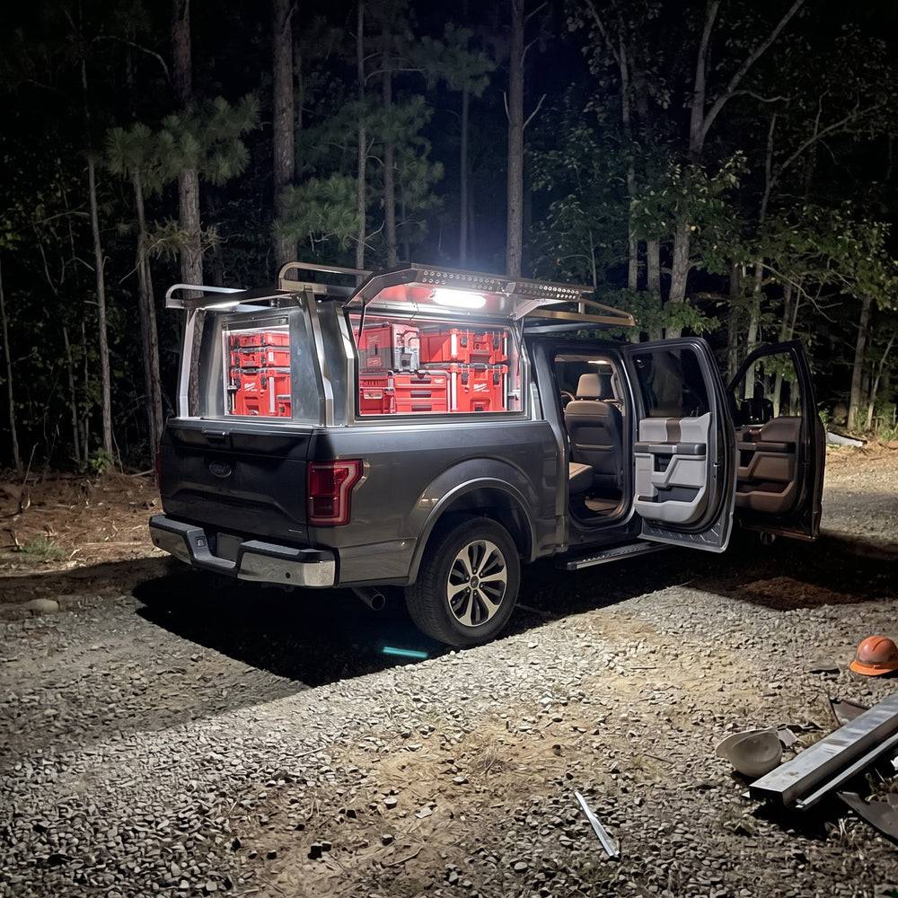 Same Ford F-150 at night lit by the LumoLux bar, tool boxes clearly visible